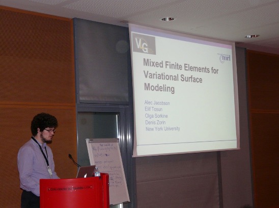 A photo of a young bearded man giving a powerpoint presentation