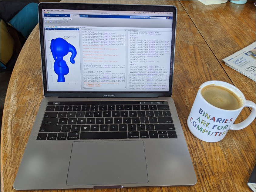 A photo of laptop with an elephant on the screen next to a coffee mug